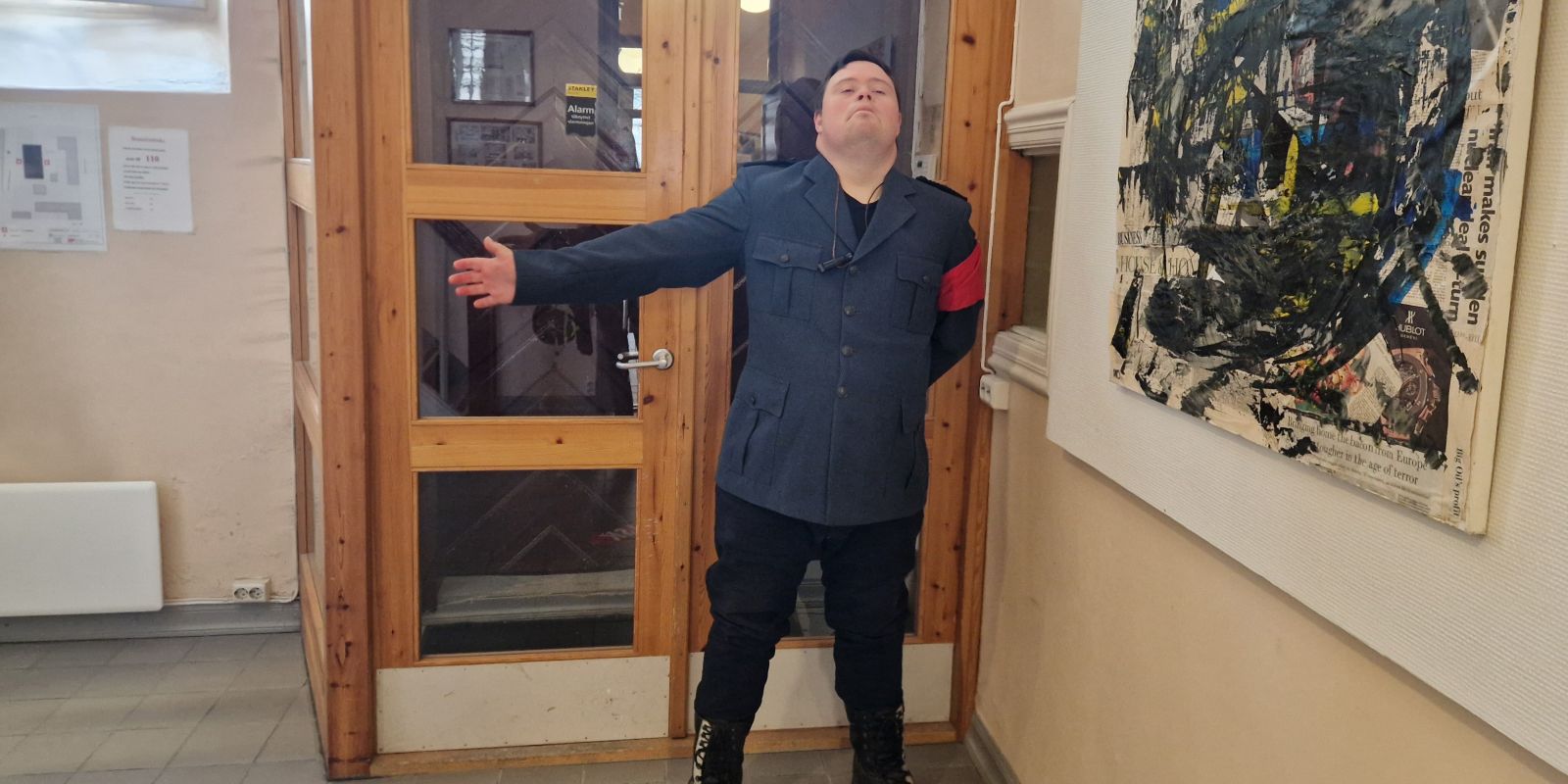 En skuespiller står inne i justismuseet med uniform 