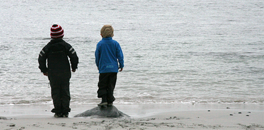 Bilde av to barn som ser utover havet