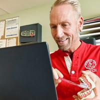 Dean Erik Andersen viser tannspuss foran pc