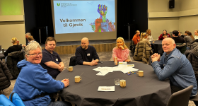 Bildet viser personer i konferansesal