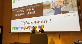 Bilde av to personer som står på en scene  