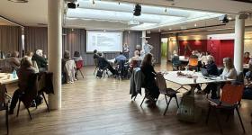 Bilde av deltakere i rundbordskonferansen Tatt bak i rommet mot scenen. 