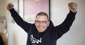 En mann rekker hendene i været copyright NAKU 